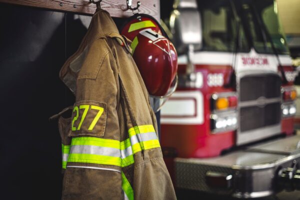 firetruck in background with firefighter uniform in foreground.