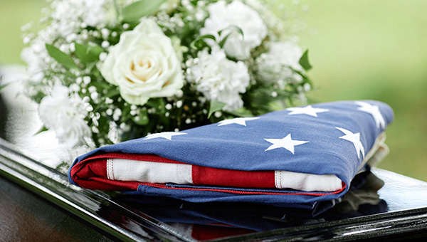 American flag on coffin with flowers